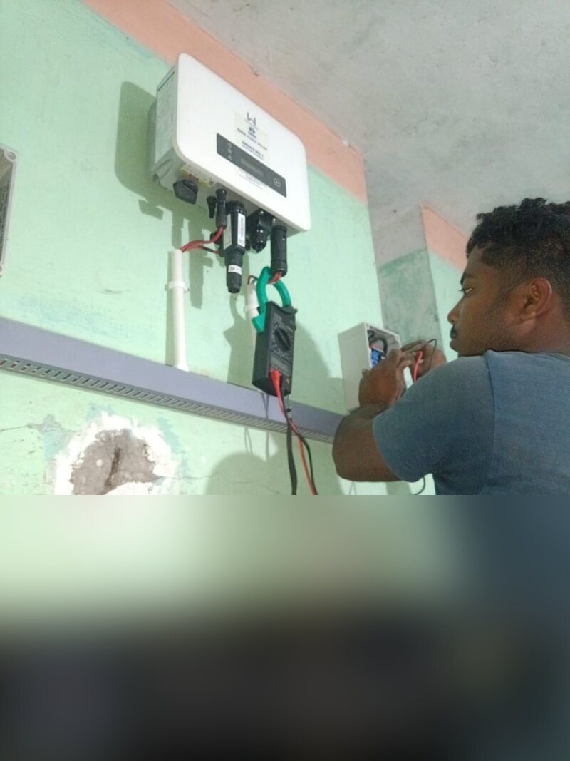 Technician checking solar inverter readings